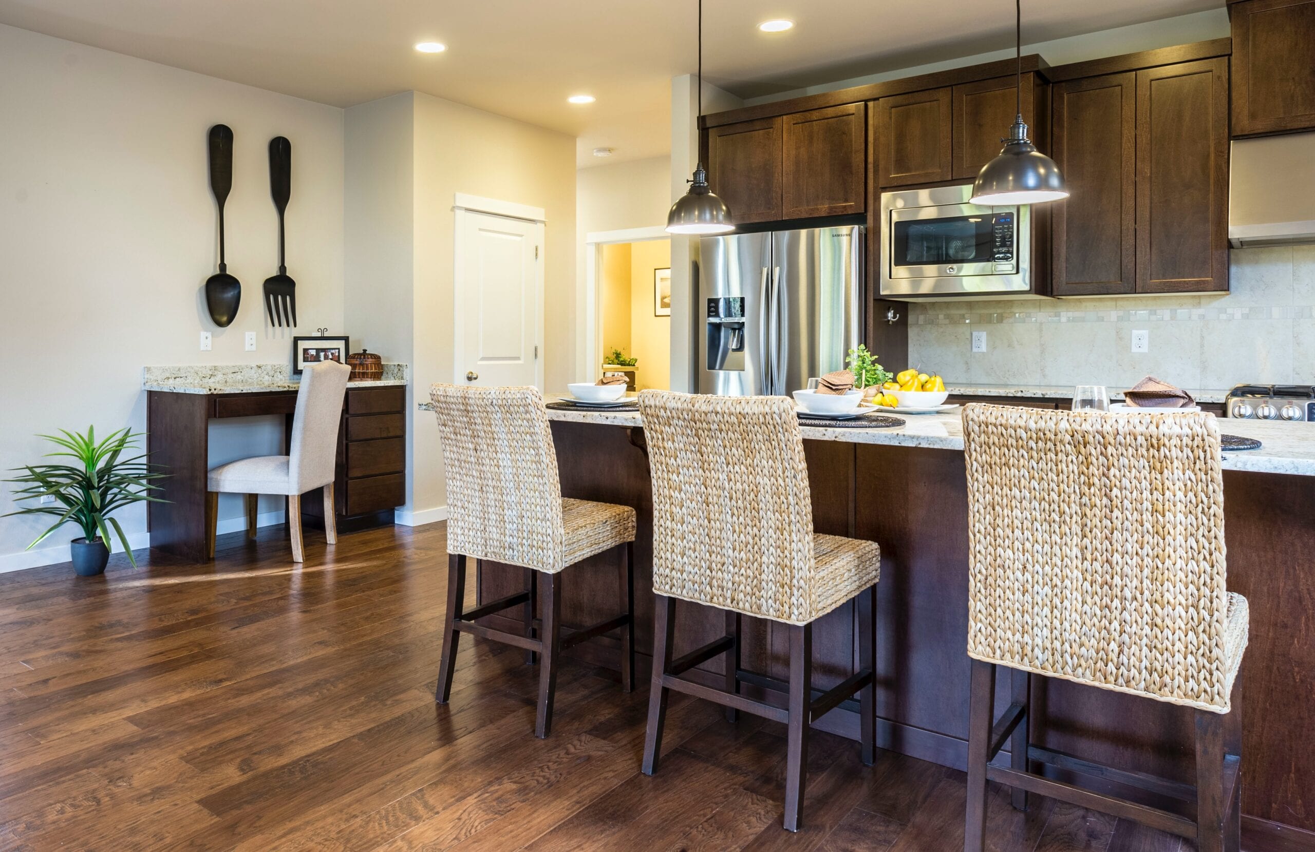 Cream coloured walls with tile backsplash and deep chocolate cabinets in a kitchen.