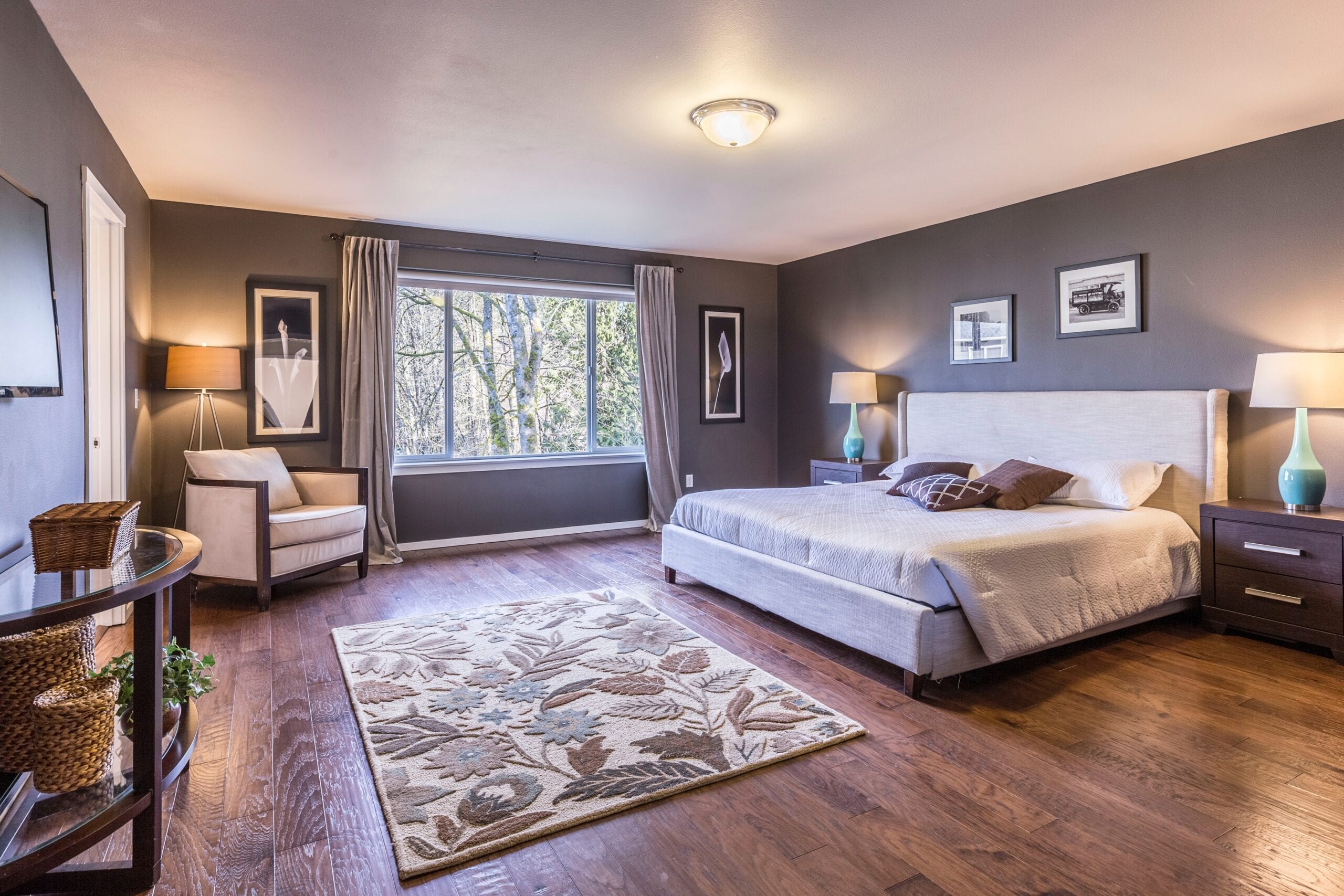 Gray interior walls with light window hanging in a large master bedroom.